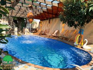 库塔伊西Garden Hotel的庭院里带椅子的大型蓝色游泳池