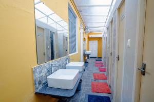 迈索尔Roambay的浴室设有3个水槽和一排镜子