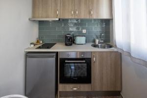 阿尔戈斯托利翁Aura central apartments的一间带水槽和洗碗机的小厨房