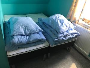 TrongisvágurDet lille gule hus的窗户间内的床上的2个枕头