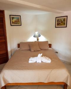 埃尔巴列德安通Hotel Valle Verde的卧室的床上的白色长袍