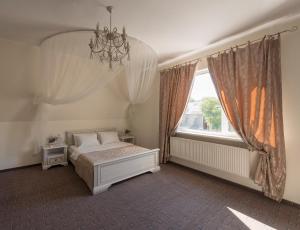 哈尔科夫利里维迷你酒店的一间卧室配有一张带吊灯和窗户的床。
