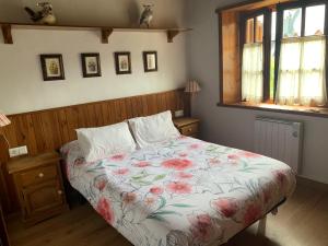普拉德埃米塔Apartemento Aiguestortes的一间卧室配有一张带花卉床罩的床