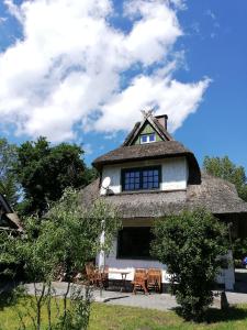 阿伦斯霍普Darßer Strandgut - Haus Butzek的茅草屋顶房屋,配有桌椅