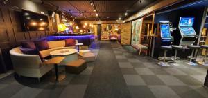 豪基普达斯Samantta Hotel & Restaurant的客房设有带沙发和桌子的酒吧。