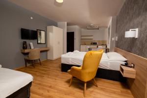 奥赫里德Apartments Bashoski的酒店客房配有一张床、一张桌子和一把椅子。