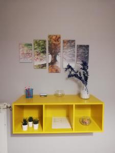 恩纳Anchida casa vacanze的黄色的橱柜,墙上挂着画作