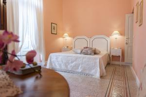 普蒂尼亚诺Casa Riccardi的卧室配有白色的床和2扇窗户。