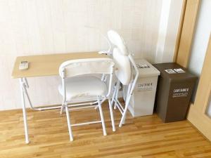 福冈ラ・フィットヤマト103的一张坐在盒子旁边的桌子上的白色椅子