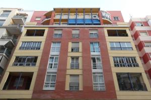 马拉加MALDONADO LUJO SUPERIOr CENTRO MALAGA的公寓大楼设有许多窗户。
