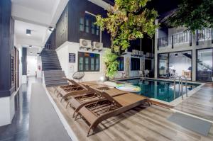 清迈Sathu Hotel的一座带游泳池和躺椅的房屋