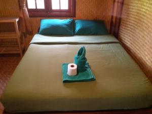 拜县普景度假村的一张带毛巾和卫生纸的床
