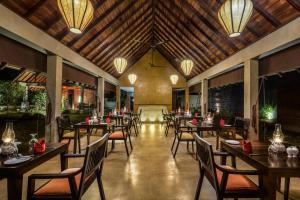 锡吉里亚Roo Mansala Boutique Villas的餐厅设有木桌和椅子及灯