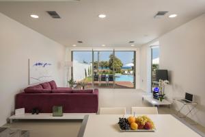 马莱迈Blue Sea Luxury Villa的客厅配有紫色沙发和带水果的桌子