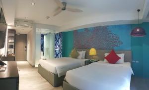 爱妮岛Lagùn Hotel的一间卧室设有两张床,墙上装饰有鱼画