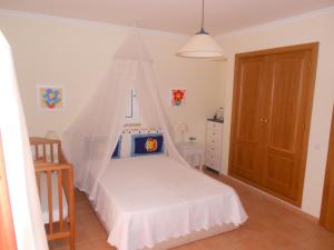阿尔图拉Algarve Praia Verde的一间卧室配有一张带蚊帐的床