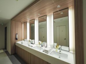 船桥市Leo Yu Capsule Hotel Funabashi的浴室设有3个水槽和一排镜子