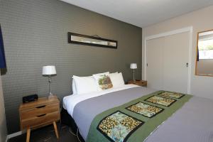 蒂阿瑙亚丁汽车旅馆的一间卧室配有一张大床和一个带四柱床的床头柜。