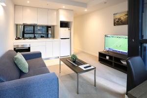 墨尔本Flinders Street Apartments的带沙发和电视的客厅以及厨房。