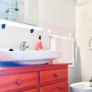科斯塔德安提瓜Appartement vue mer et soleil toute l année的一间带白色水槽和红色木橱柜的浴室