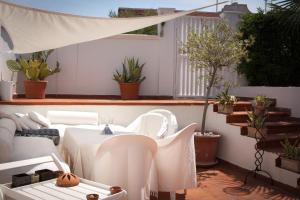 维拉诺瓦B&B D'A mare的庭院配有白色的桌子、椅子和植物