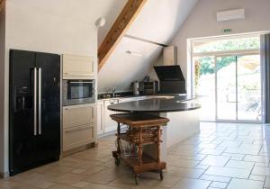 Le ViganDomaine de Janis & Spa的厨房配有黑色冰箱和桌子