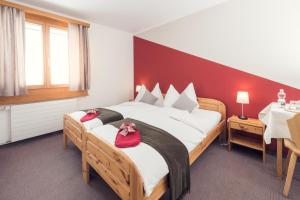 波尼纳豪瑟贝豪斯迪亚沃勒扎酒店的一间卧室配有一张大床,上面有红色的鞋