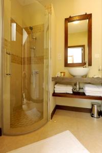 格兰贝伊Athena Villas by Fine & Country的带淋浴、盥洗盆和镜子的浴室