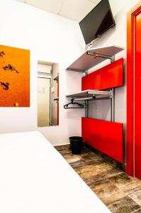 帕洛斯德拉夫龙特拉ALIOCIO的一间设有红色橱柜和墙上电视的房间