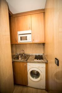 索里亚Hostal Caballeros的厨房配有洗衣机和微波炉。