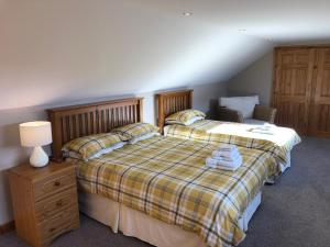 坎贝尔城Inveroran的一间卧室配有一张床、一盏灯和一把椅子