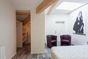 索恩河畔自由城Grand duplex au calme en centre-ville的一间卧室配有两张紫色椅子和一张床