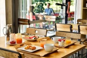 Bastelica阿特米西亚精品酒店的一张木桌,上面摆放着早餐食品和饮料