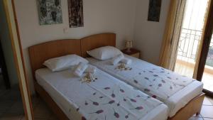 尼基季Natalia's Apartments的一间卧室配有一张带白色床单和蝴蝶的大床