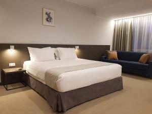 拉姆尼库沃尔恰NOVO Boutique的一间卧室配有一张大床和一张蓝色的沙发