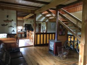 科查莫La Casona Puelo Lodge的一间带燃木炉和楼梯的客厅
