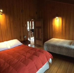科查莫La Casona Puelo Lodge的一间卧室设有两张床和木镶板墙