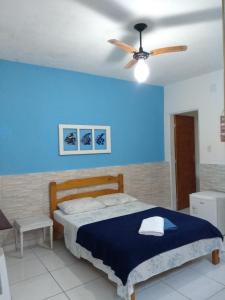 乌巴图巴Suítes Veleiro的一间卧室配有一张床和吊扇