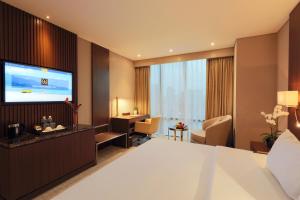 河内Grand Vista Hanoi的配有一张床和一台平面电视的酒店客房