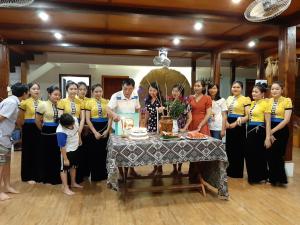 枚州县Mai Chau Dreams Homestay的一群人站在桌子旁,拿着蛋糕