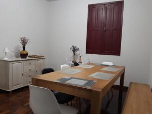 欧鲁普雷图Casa Vermelha的一间带木桌和白色椅子的用餐室