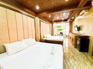 长滩岛Kaiyana Boracay Beach Resort的卧室配有一张白色大床和电视。