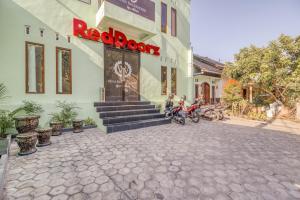 日惹RedDoorz near Jogja National Museum的停在外面有一辆摩托车的建筑