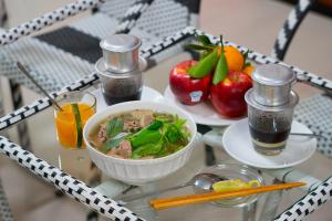 胡志明市Ben Thanh Retreats Hotel的桌上放着一碗汤和水果
