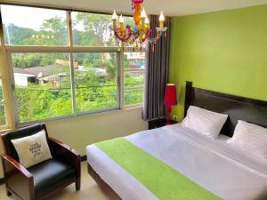 华欣Baan Nilawan Hua Hin Hotel的一间卧室配有一张床、一个吊灯和一扇窗户