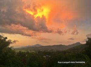 浦阿Pua Tranquil Vista Homestay的享有日落美景和山脉背景