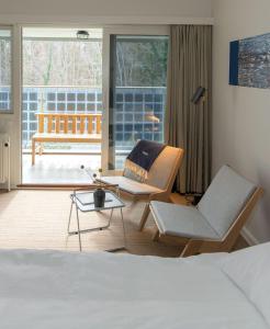 伦讷GSH酒店的酒店客房设有床和椅子以及庭院。