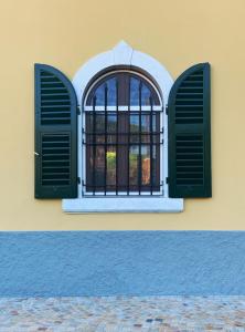 卡拉拉Mikeme的黄色建筑上带绿色百叶窗的窗户