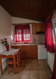 卡托劳塔翁多西亚酒店的厨房配有桌子、水槽和红色窗帘