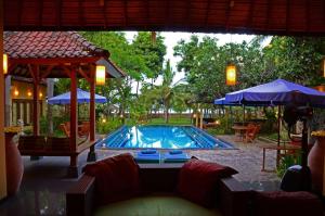 特贾库拉巴厘岛自然酒店的一个带沙发和遮阳伞的游泳池